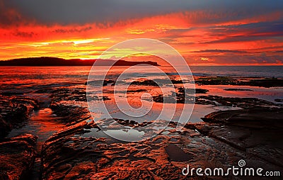 Red sunrise blankets Pearl Beach Australia Stock Photo