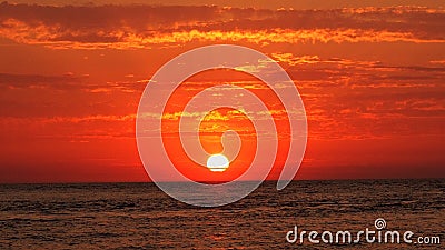 Sunset dark red clouds over sea Stock Photo