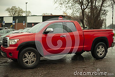 A red SUV is parked in the city. The pickup truck is on a groan Stock Photo