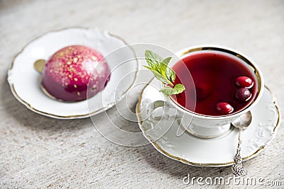 Red tea hibiscus in a vintage cup, antique spoon, cake, raspberry. Copy space Stock Photo