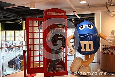 Red telephone booth typical english london and a giant anthropomorphic famous chocolate Editorial Stock Photo