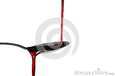 Red thick liquid brimming over on the spoon on the white background Stock Photo
