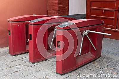 Red three tripod turnstile metal gates entrance for access control in China. Entrance or exit turnstile tripod and ticket reader Stock Photo