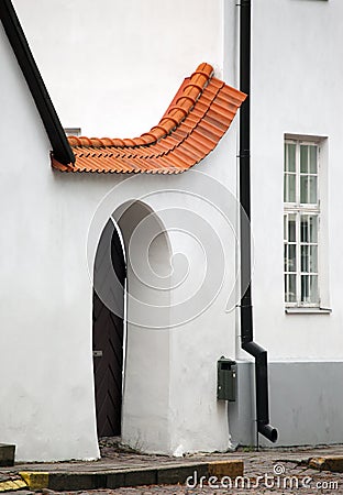 Red tile drain over a door in the white plastered wall of the medieval building, Tallinn Stock Photo