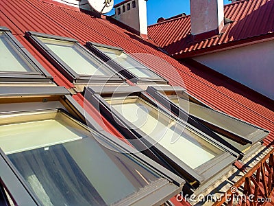 Red tiled house roof with attic windows. Roofing construction, window installation, modern architecture concept Stock Photo