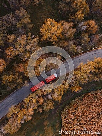 Red tipper truck on street road highway transportation. Semi-truck autumn countryside aerial view Stock Photo