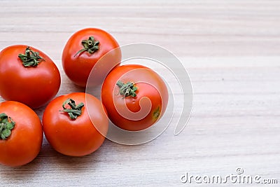 Red tomato on plain wooden table, essential vegetables for all essential foods, view of unpeeled vegetables with plain background Stock Photo