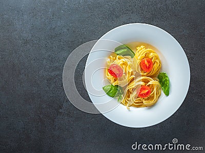 Red tomatoes and italian pasta with bazil leaves in plate with free space Stock Photo