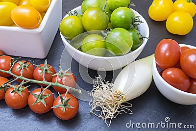 Red tomatoes, yellows, greens and chives Stock Photo