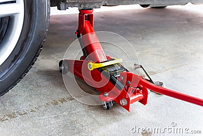 Red tool jack lift car for repair check Maintenance Stock Photo