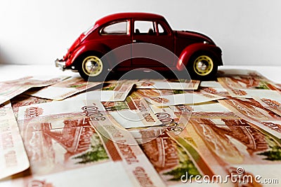 Red toy car on the background of Russian money bills. Buying a new car on credit and by installments.Russian banknotes Stock Photo