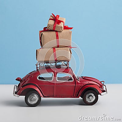 Red toy car Volkswagen Beetle riding with New Year gift on the top Editorial Stock Photo