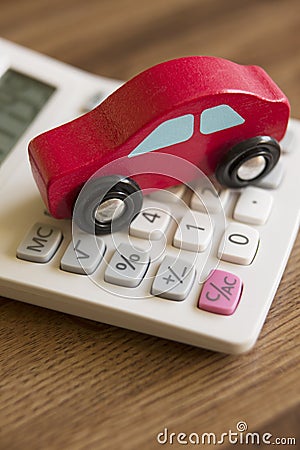 Red Toy Wooden Car On Calculator To Illustrate Cost Of Motoring Stock Photo