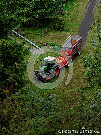 Red tractor carry empty carrier in the woods Stock Photo