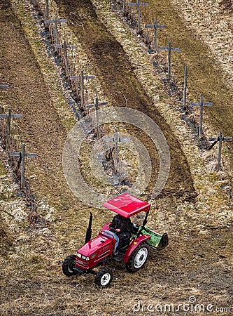 Red Tractor Working in Field Editorial Stock Photo