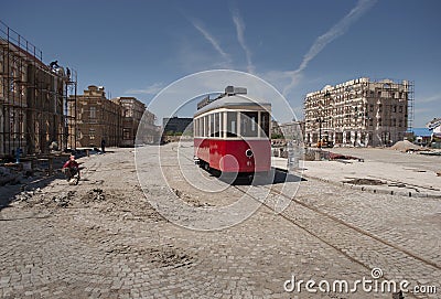 Red tram and cobble streets under construction Stock Photo