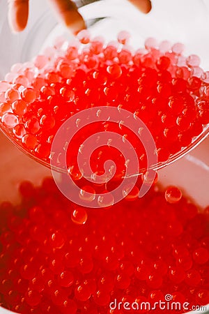 Red transparent hydrogel balls falling into a vase Stock Photo