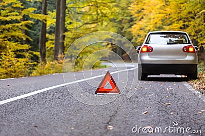 Red triangle of a car on the road.Broken car in forest.damage ca Stock Photo