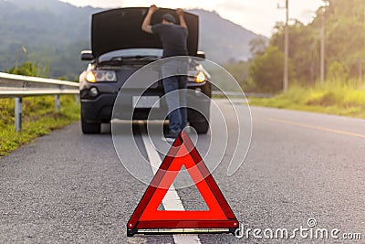 Red triangle sign on road for warning have car with breakdown open car hood and man fixing a car Stock Photo