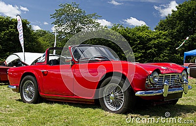 a bright red Triumph sports car on display at a classic car show in Wales Editorial Stock Photo