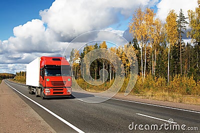 Red truck on autumn highway Stock Photo