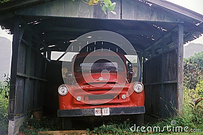 A red truck under an old carport in Hawaii Editorial Stock Photo
