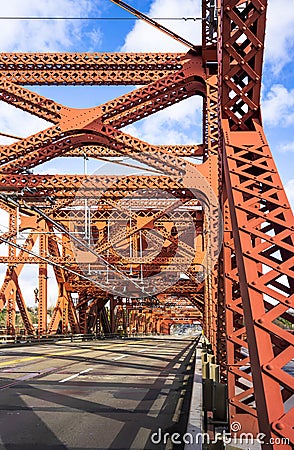 Red truss Broadway drawbridge across Willamette River in Portland down Town at sunny day with cloud sky Stock Photo