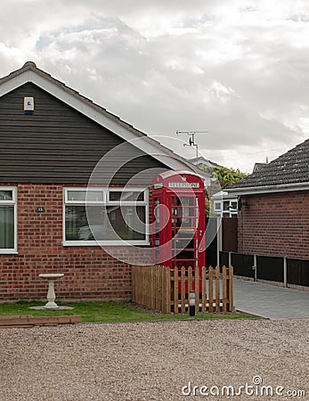 Red uk telephone box outside of house Stock Photo