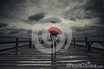 Red umbrella in storm Stock Photo