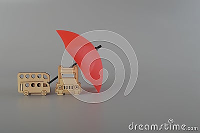 Red umbrella and toy vehicles. Vehicle insurance, warranty, repair, financial, banking and money concept Stock Photo