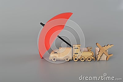 Red umbrella and wooden toy vehicles. Vehicle insurance, warranty, repair, financial, banking and money concept Stock Photo