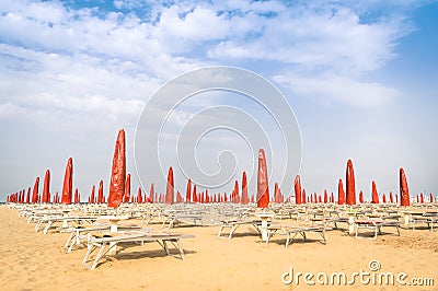 Red umbrellas and sunbeds at Rimini Beach - Italian summer Stock Photo