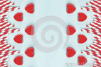 Red valentines and striped straws on mint color paper as decorative abstract festive background for Valentine`s day. Stock Photo