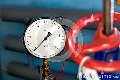 Red valve and pressure sensor on the gas supply or heating pipe. Stock Photo