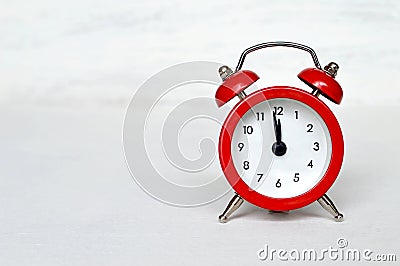 Red vintage alarm clock striking midnight (or midday) Stock Photo