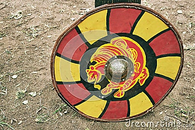 Red vintage shield with yellow animal lion a medieval warrior. Reconstruction of the events of the Middle Ages in Europe Stock Photo