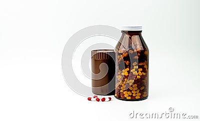 Red, white antibiotic capsules pills and two amber bottles isolated on white background with copy space and blank label. Stock Photo
