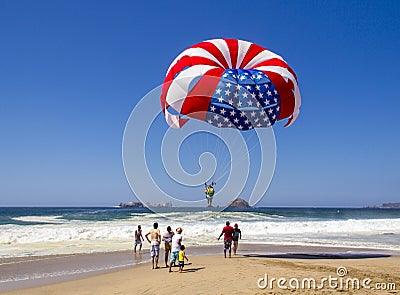 Red, white and blue of American flag parasail against bright blue sky. Stock Photo