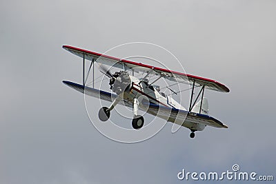 Red, White, and Blue Biplane Flying in the Sky Stock Photo