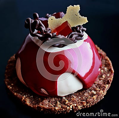 Red and white dessert with chocolate decoration, red jelly and cookie base Stock Photo