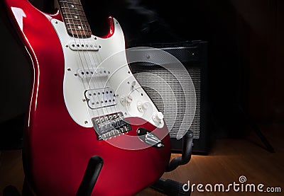 Red and white electric guitar and combo amplifier on black background Stock Photo