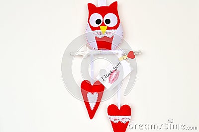 Red and white felt owl on wood branch, 2 hearts, handmade toys Stock Photo