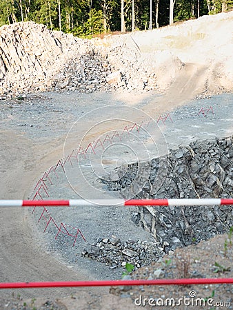 Red white fence round open mine. Danger place with landslide, Stock Photo