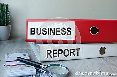 Red and white folders with documents lying on the desktop next to a calculator and a pen. The lettering on the folder has Stock Photo