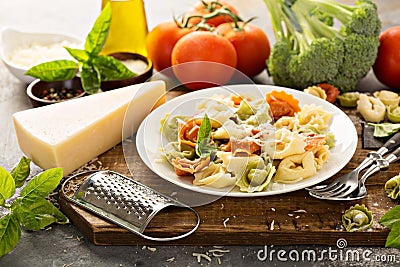 Red, white and green tortellini with vegetables and cheese Stock Photo