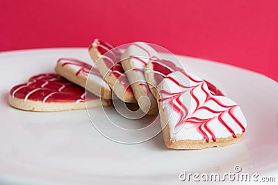 Red and White, heart shaped cookies on a plate with red background Stock Photo