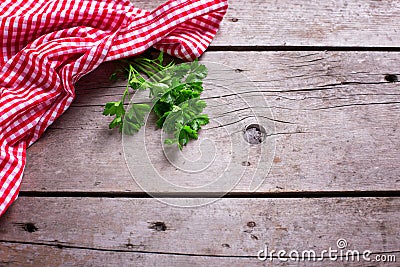 Red and white kitchen towel and green parsley leaves on rustic Stock Photo