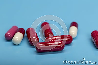 Red-white medicinal capsules on blue background Stock Photo