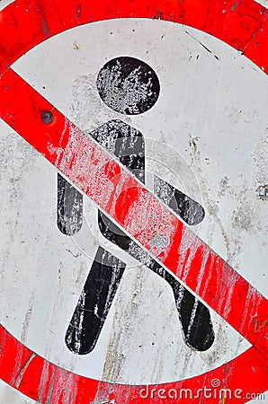 A red-and-white sign, smeared with paint, dirt, and cracks - a person is not allowed to pass. Stock Photo