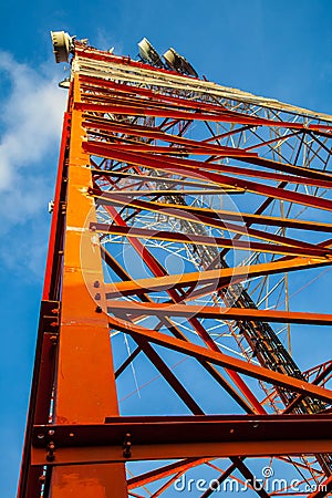 Red white telecommunication tower against blue sky - bottom view Stock Photo